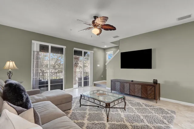 a living room with furniture a flat screen tv and a window