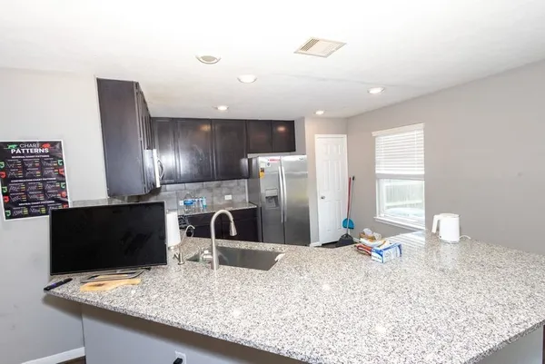 a kitchen with stainless steel appliances kitchen island granite countertop a refrigerator stove and oven