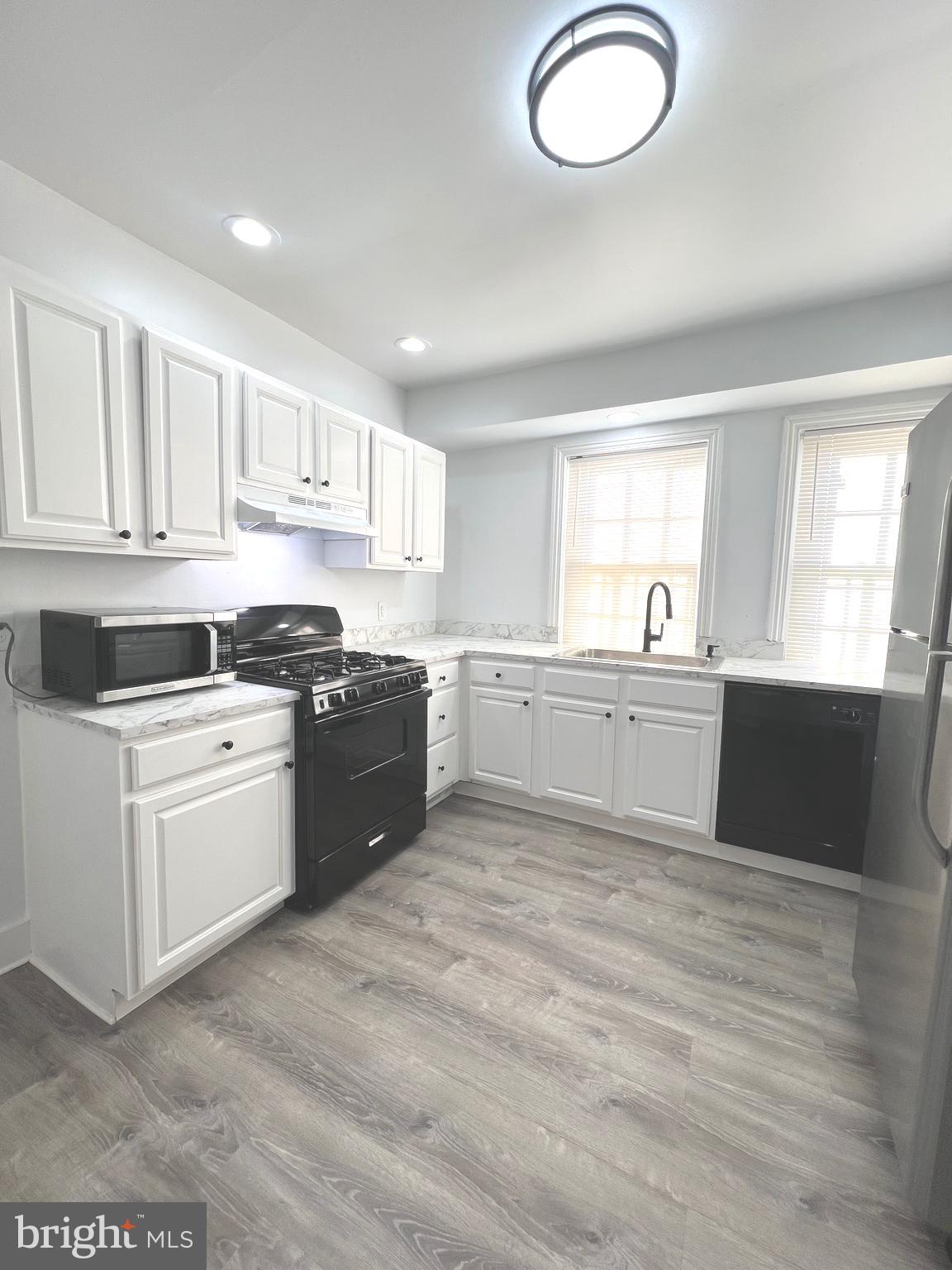 405 North 2nd Street Camden, NJ 08102 - Photo 6 of 15 a kitchen with granite countertop a sink white cabinets and stainless steel appliances