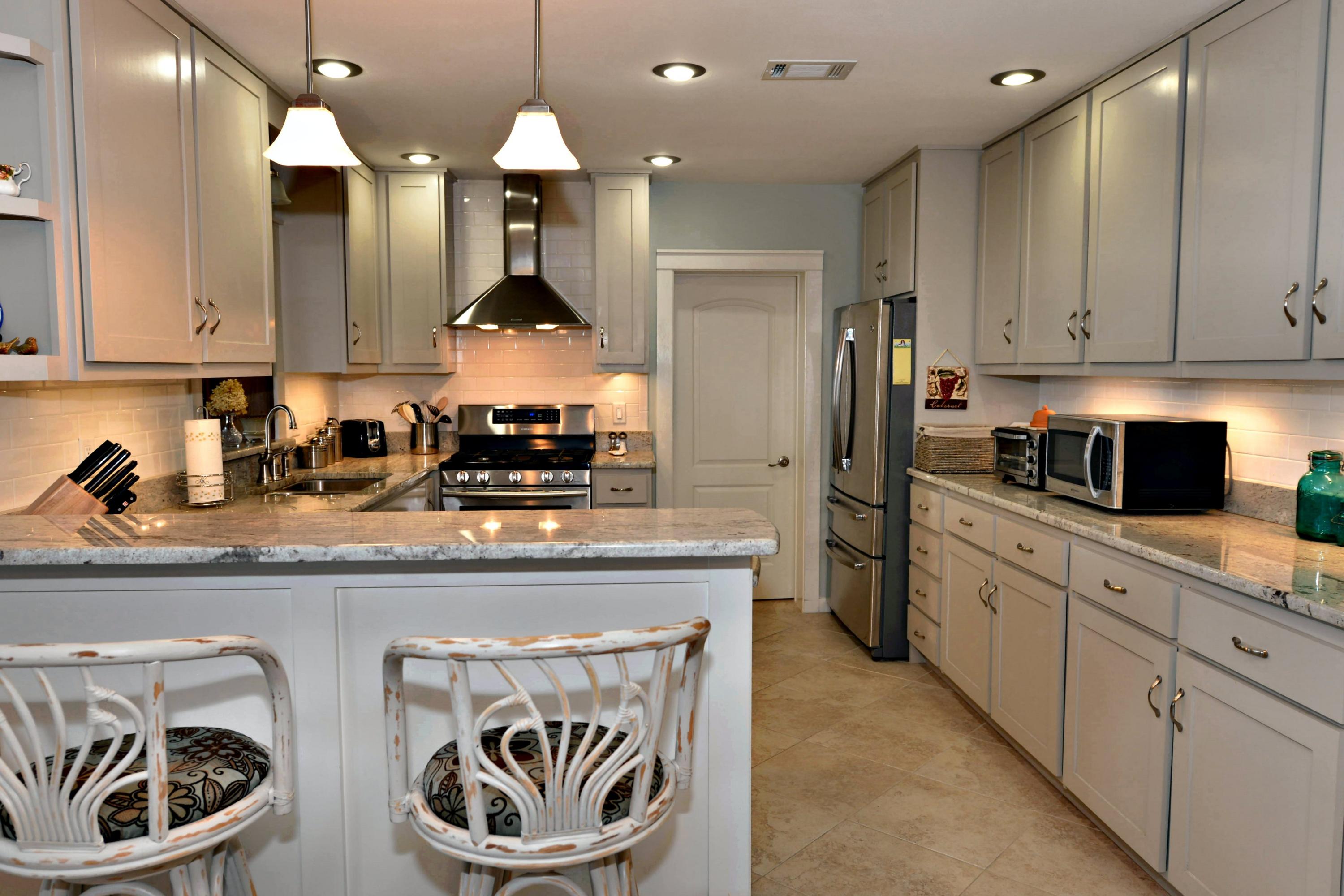 2394 Bay Grove Road Freeport, FL 32439 - Photo 5 of 37 a kitchen with stainless steel appliances granite countertop a stove a sink and a refrigerator