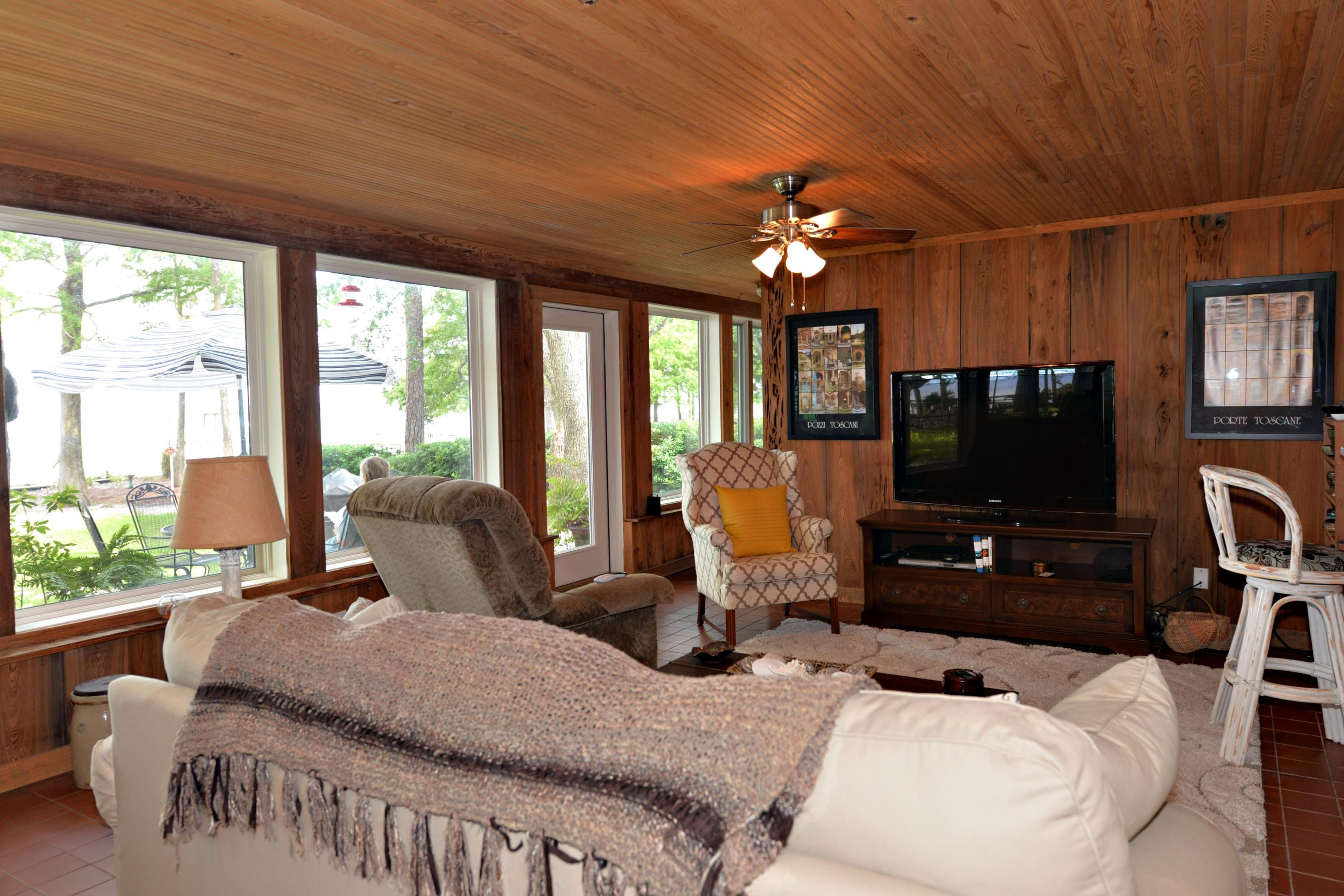 2394 Bay Grove Road Freeport, FL 32439 - Photo 9 of 37 a living room with furniture a flat screen tv and a floor to ceiling window