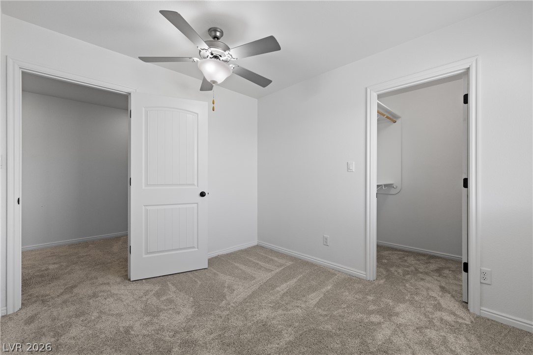 575 Gann Avenue Logandale, NV 89021 - Photo 41 of 75 A well-lit room offers comfort with plush carpeting and a modern ceiling fan.