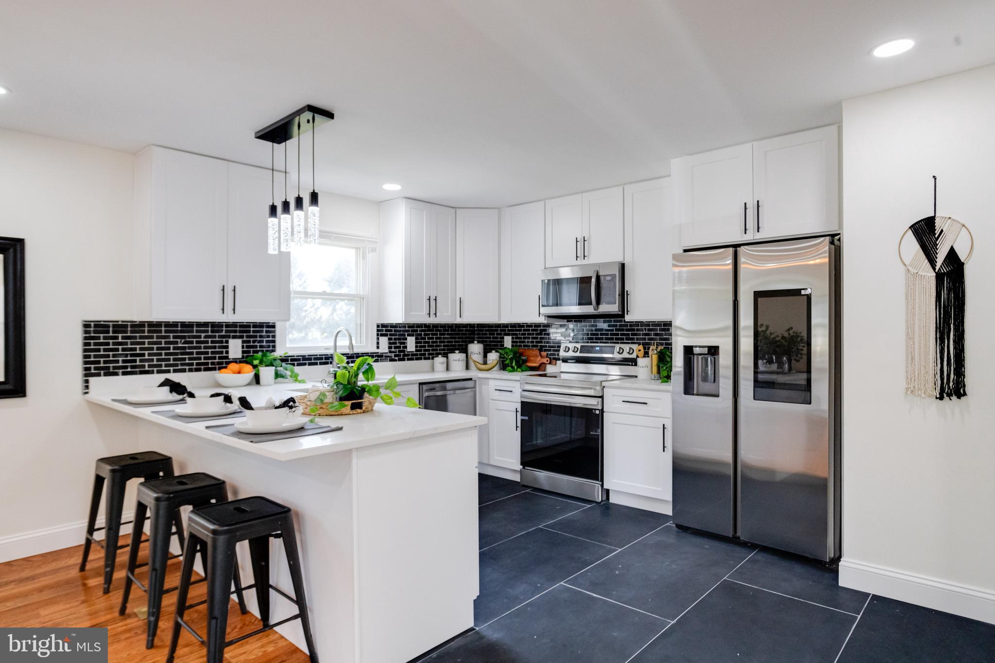 8041 Edgewater Avenue Rosedale, MD 21237 - Photo 10 of 38 a kitchen with stainless steel appliances kitchen island a refrigerator sink and cabinets