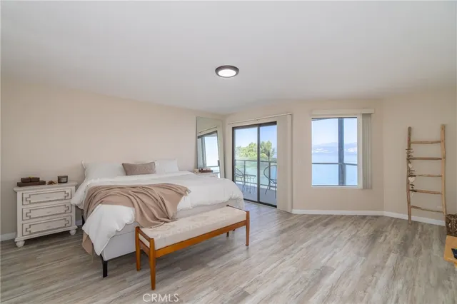 a spacious bedroom with a bed and wooden floor