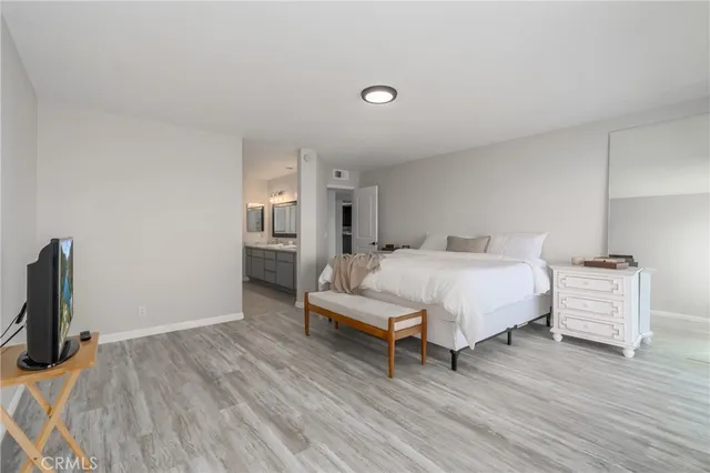 a large bed sitting in a spacious bedroom next to a window and a flat screen tv