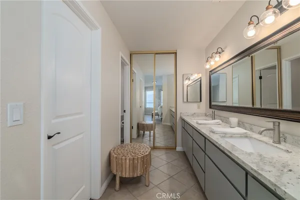 a spacious bathroom with a granite countertop sink and a mirror