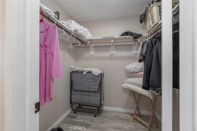 a view of walk in closet with clothes and shoes