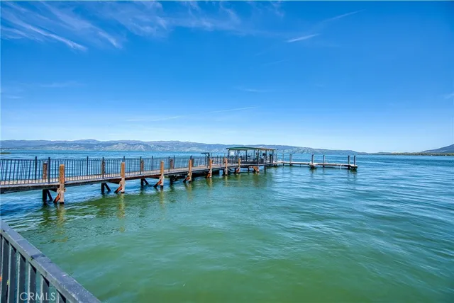 a view of swimming pool with lawn chairs and plants