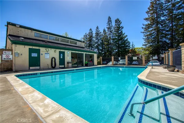 a view of a house with pool fire pit a patio and a garden