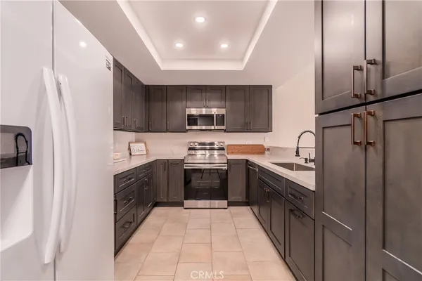 a large kitchen with stainless steel appliances granite countertop a stove top oven a sink and dishwasher
