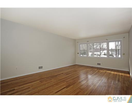 5 Roney Road Edison, NJ 08820 - Photo 13 of 25 a view of an empty room with wooden floor and a window