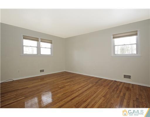 5 Roney Road Edison, NJ 08820 - Photo 20 of 25 a view of an empty room with wooden floor and a window