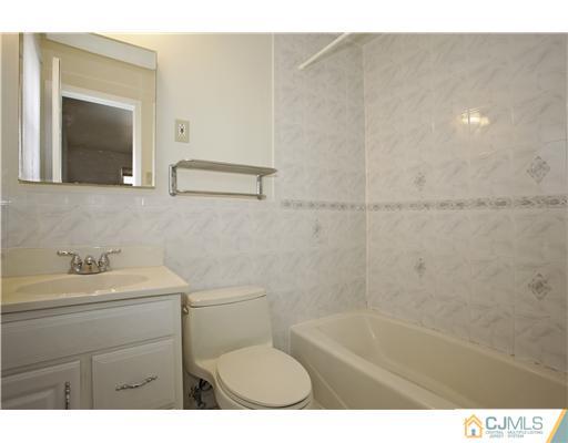 5 Roney Road Edison, NJ 08820 - Photo 23 of 25 a bathroom with a sink a toilet and a mirror