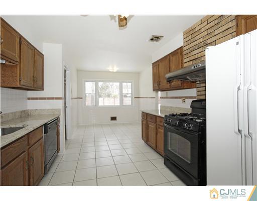 5 Roney Road Edison, NJ 08820 - Photo 8 of 25 a kitchen with granite countertop a refrigerator stove top oven and sink
