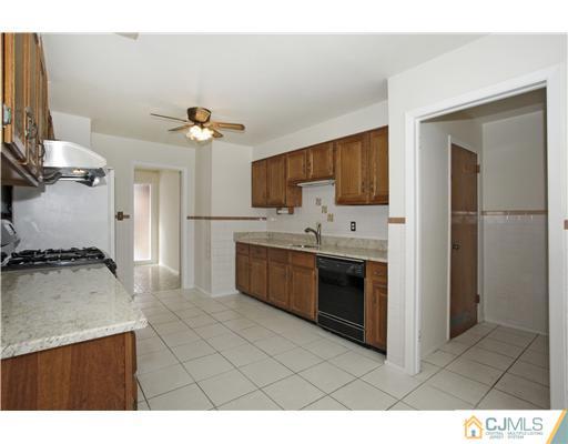 5 Roney Road Edison, NJ 08820 - Photo 9 of 25 a kitchen with stainless steel appliances a stove a sink and a refrigerator