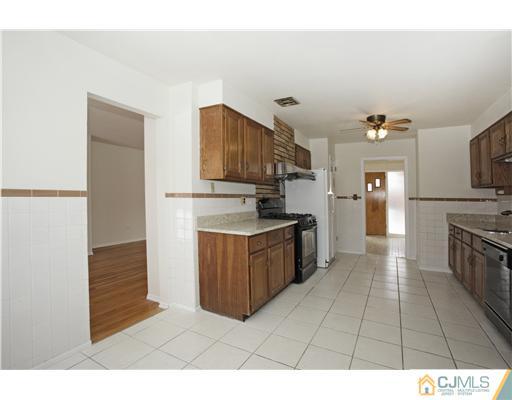 5 Roney Road Edison, NJ 08820 - Photo 10 of 25 a kitchen with a refrigerator and a stove top oven