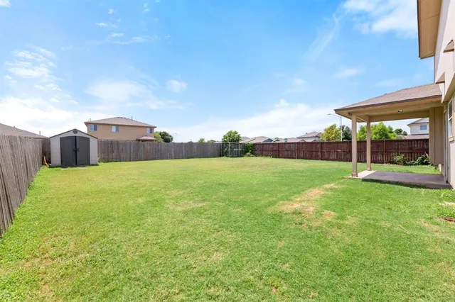 a view of a house with backyard porch and wooden fence