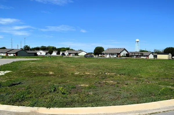 a view of a field of grass and houses