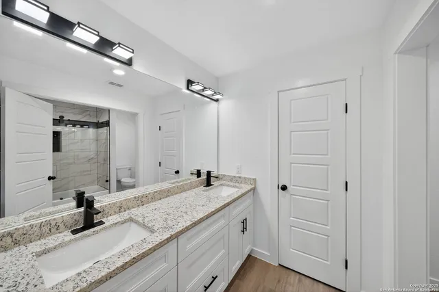 a bathroom with a granite countertop sink and a mirror