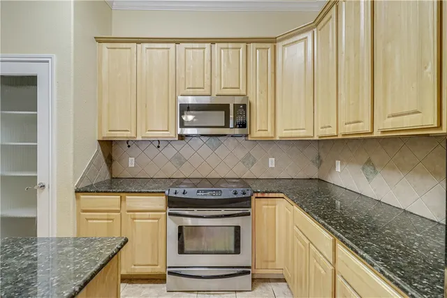 a kitchen with stainless steel appliances granite countertop a stove a microwave and a sink