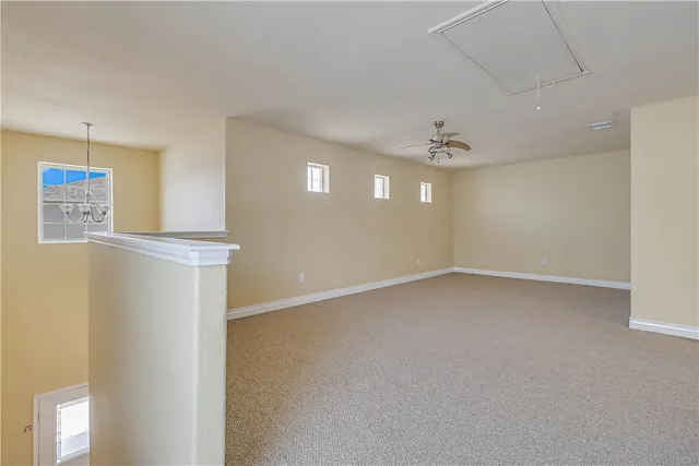 an empty room with a window and a ceiling fan