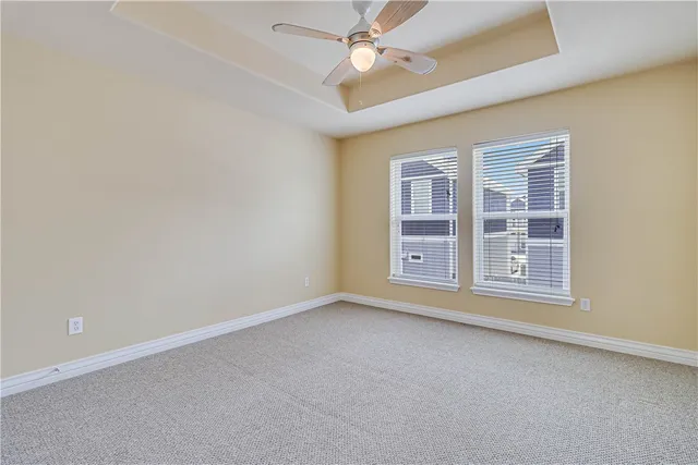 an empty room with a window and ceiling fan