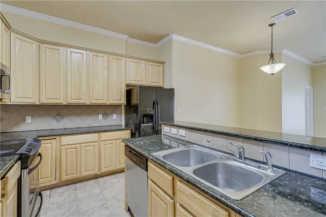 a kitchen with granite countertop a sink a stove and cabinets