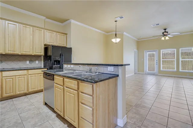 a kitchen with a stove a sink cabinets and a window