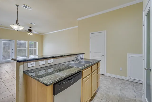 a kitchen with a stove a refrigerator and chandelier