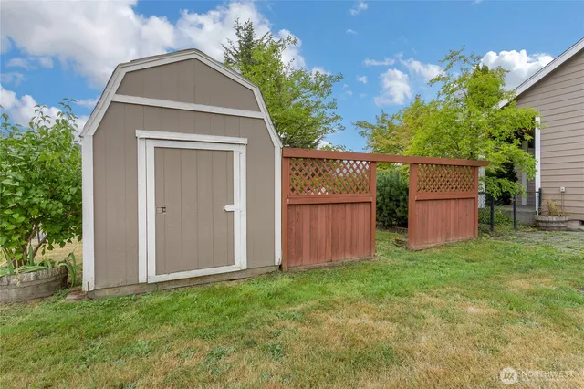 a view of backyard of house with wooden fence