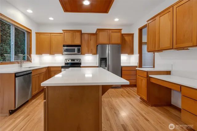 a kitchen with a sink a counter top space stainless steel appliances and cabinets