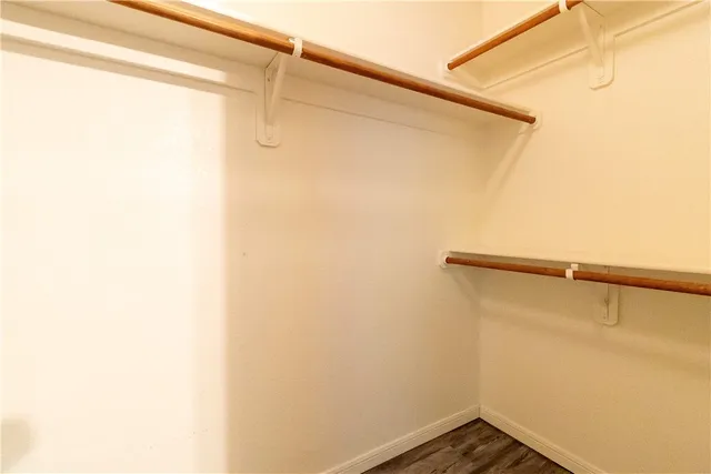 a view of an empty room with window and a chandelier fan