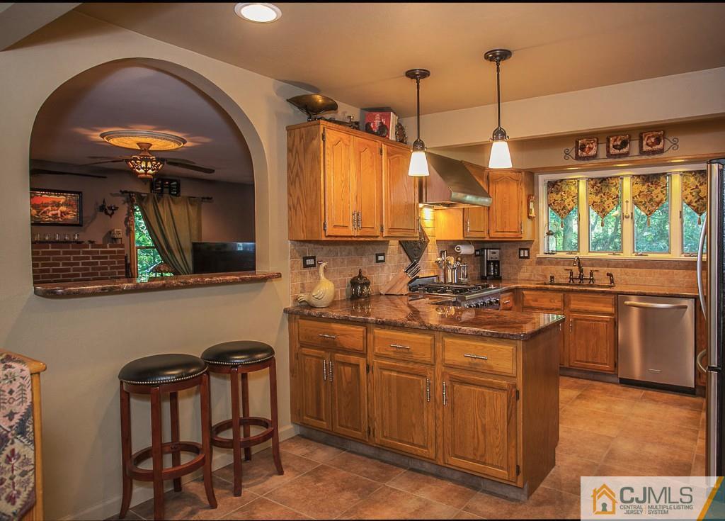 68 Richard Road Edison, NJ 08820 - Photo 13 of 25 a kitchen with stainless steel appliances granite countertop a sink a stove and a wooden floors