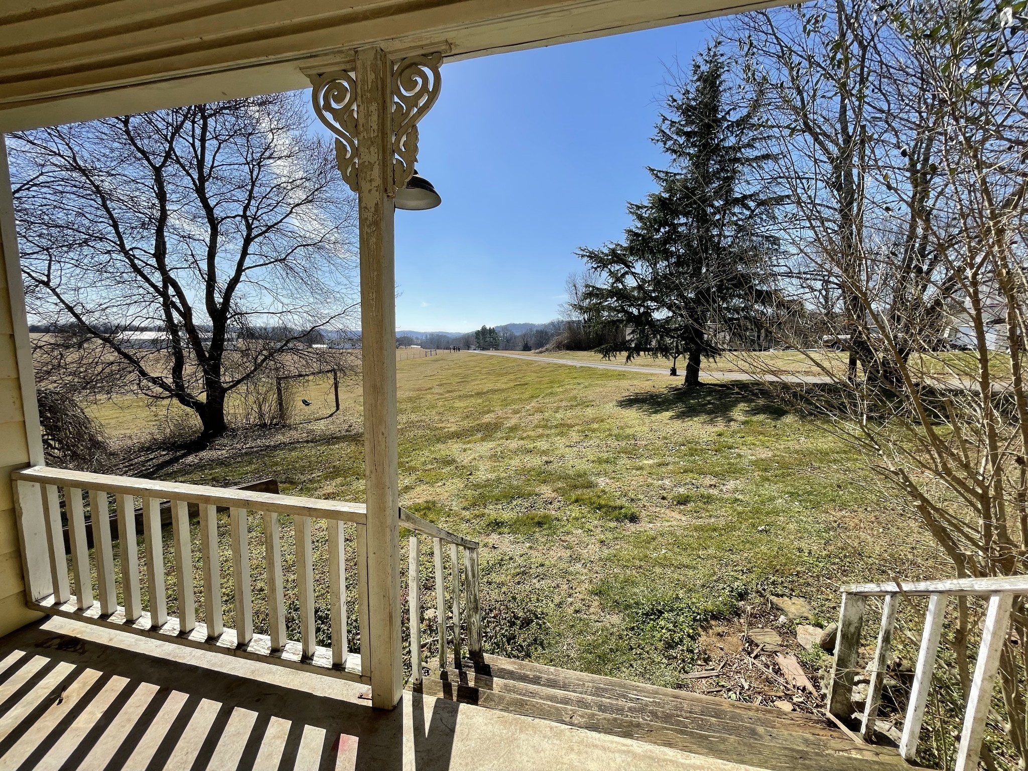 a view of a yard with wooden fence and trees