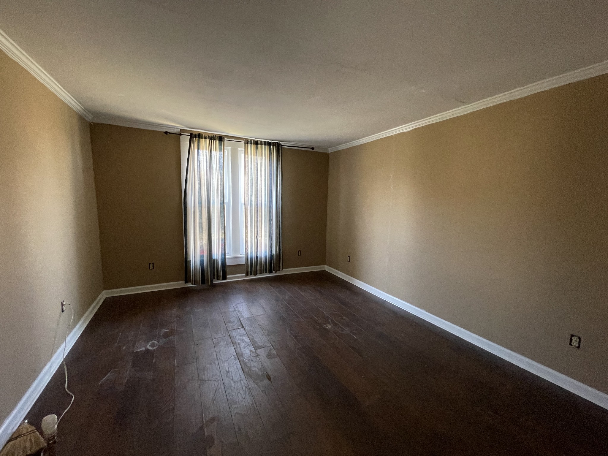 313 Smith Road Cornersville, TN 37047 - Photo 25 of 27 an empty room with wooden floor and windows with curtains