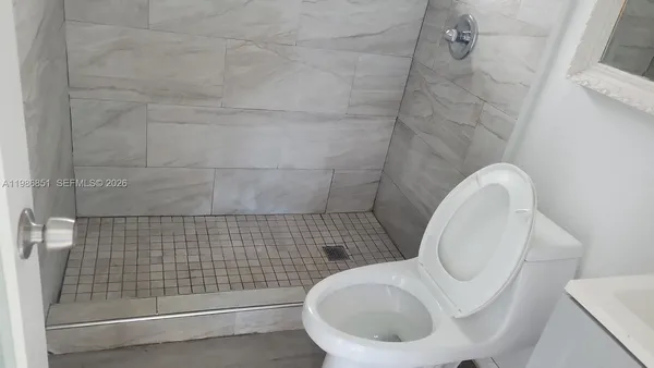 a bathroom with a toilet and a shower