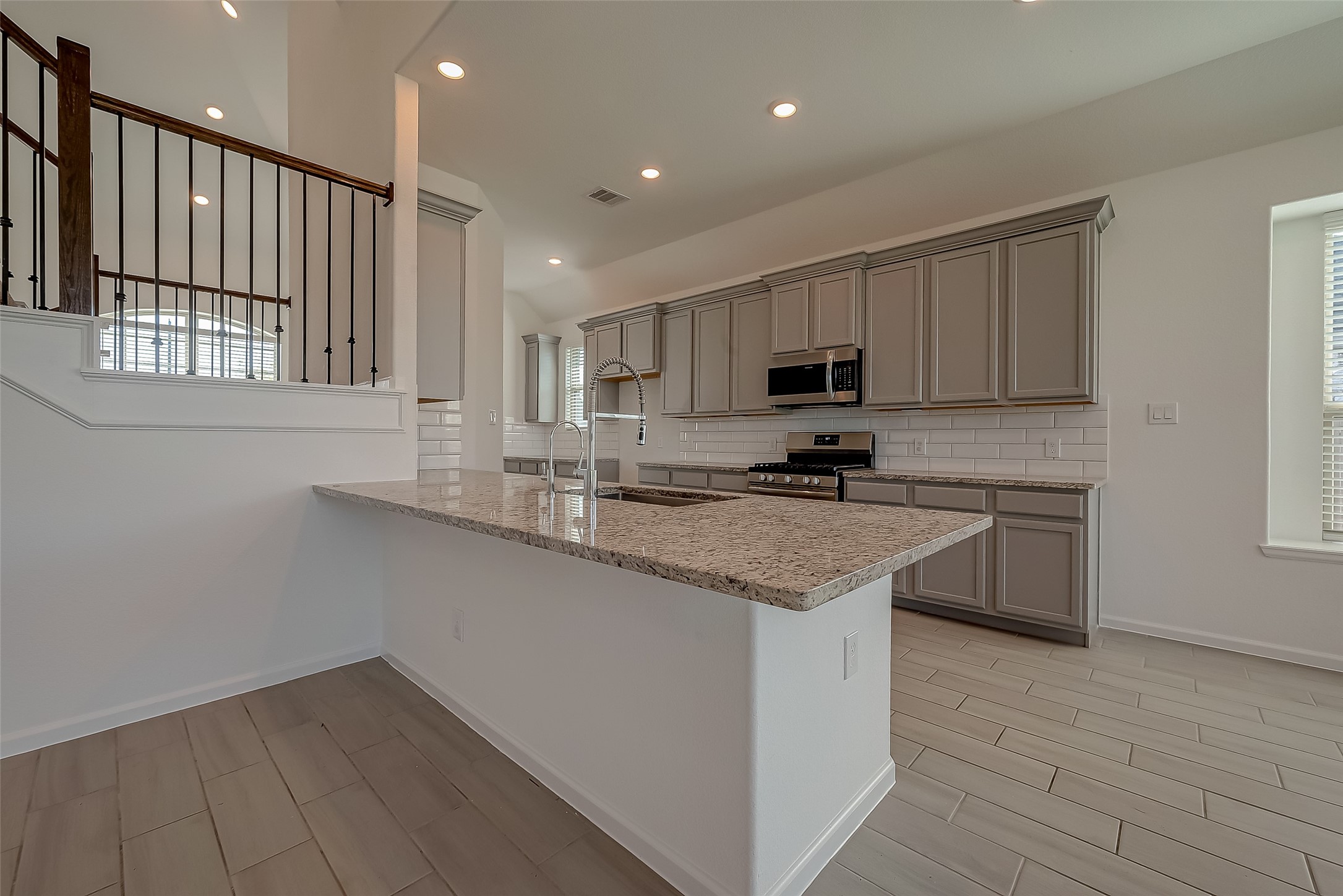 5010 Slate Prt Court Rosenberg, TX 77469 - Photo 10 of 39 a kitchen with granite countertop a stove a sink and a microwave