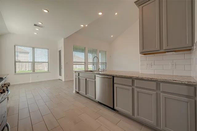 a large kitchen with stainless steel appliances granite countertop a lot of counter space and wooden floor