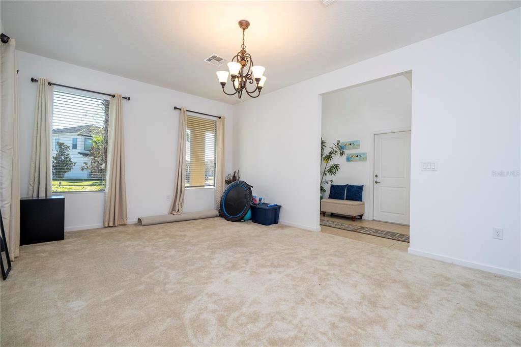 4561 Cabello Loop Kissimmee, FL 34746 - Photo 23 of 100 a view of a livingroom with a chandelier curtains and large windows