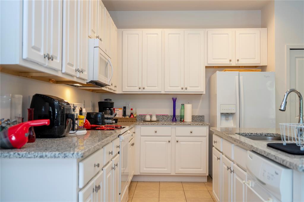 4561 Cabello Loop Kissimmee, FL 34746 - Photo 30 of 100 a kitchen with granite countertop a sink stainless steel appliances and cabinets