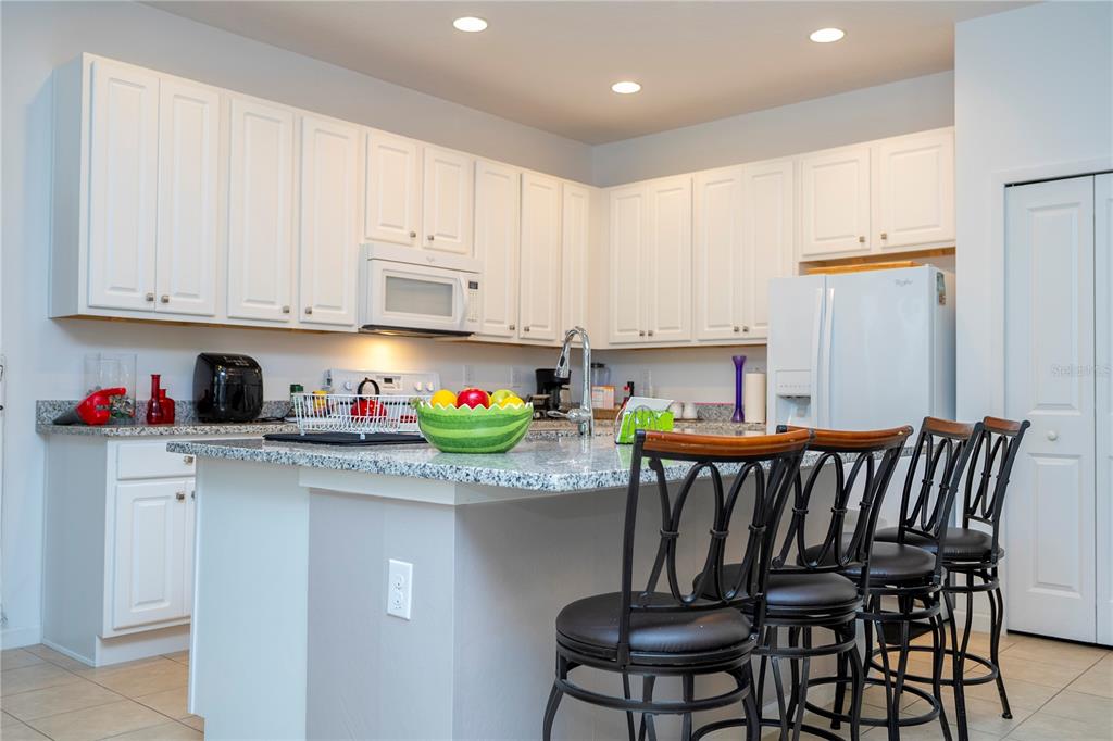 4561 Cabello Loop Kissimmee, FL 34746 - Photo 34 of 100 a view of kitchen with stainless steel appliances granite countertop a stove top oven a sink and white cabinets