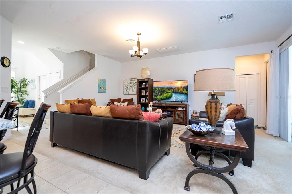 4561 Cabello Loop Kissimmee, FL 34746 - Photo 39 of 100 a living room with furniture a chandelier and a mirror