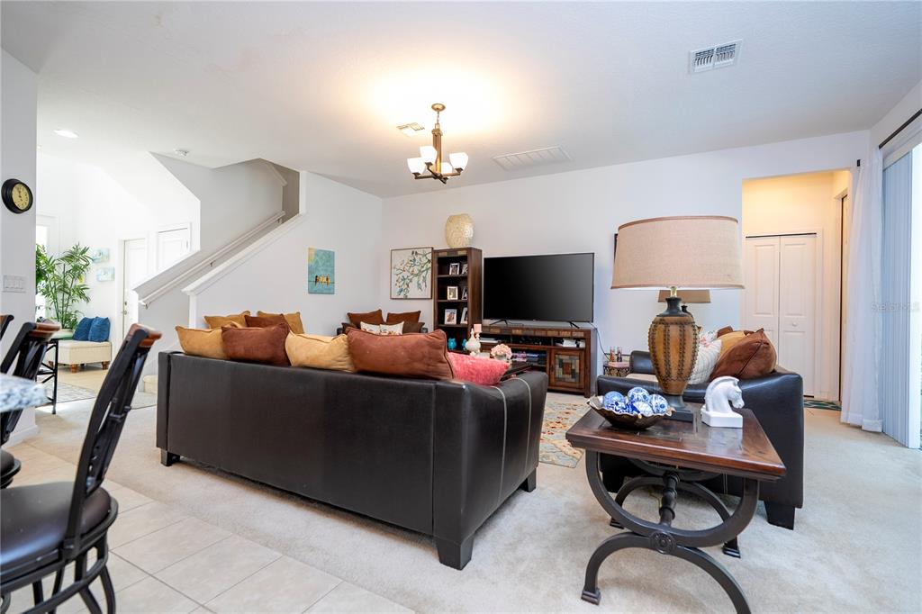 4561 Cabello Loop Kissimmee, FL 34746 - Photo 40 of 100 a living room with furniture a chandelier and a flat screen tv