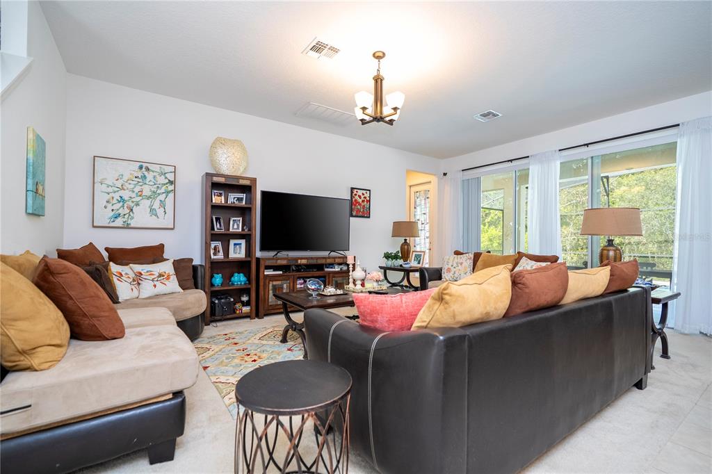 4561 Cabello Loop Kissimmee, FL 34746 - Photo 42 of 100 a living room with furniture a large window and a flat screen tv