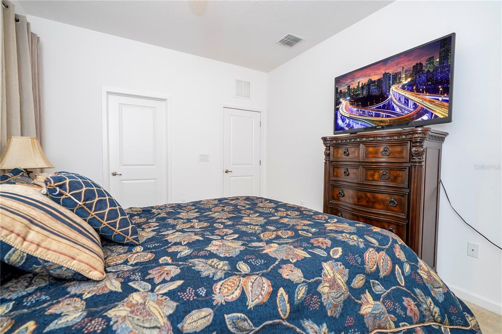 4561 Cabello Loop Kissimmee, FL 34746 - Photo 49 of 100 a bedroom with a bed and a painting on the wall