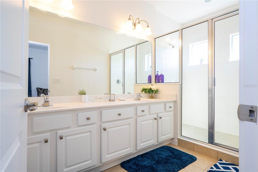 4561 Cabello Loop Kissimmee, FL 34746 - Photo 86 of 100 a bathroom with a double vanity sink and mirror