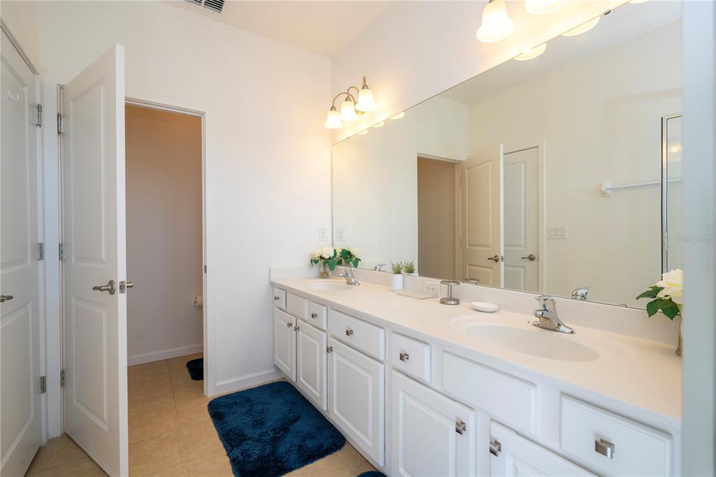 4561 Cabello Loop Kissimmee, FL 34746 - Photo 88 of 100 a spacious bathroom with a double vanity sink a mirror and a shower