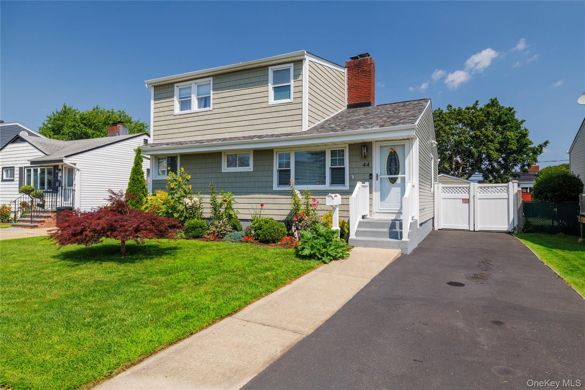 a front view of a house with a garden and plants