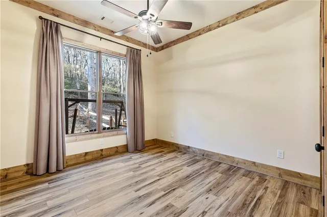 a view of a livingroom with wooden floor and staircase
