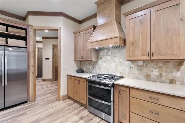 a kitchen with stainless steel appliances a stove a refrigerator and cabinets
